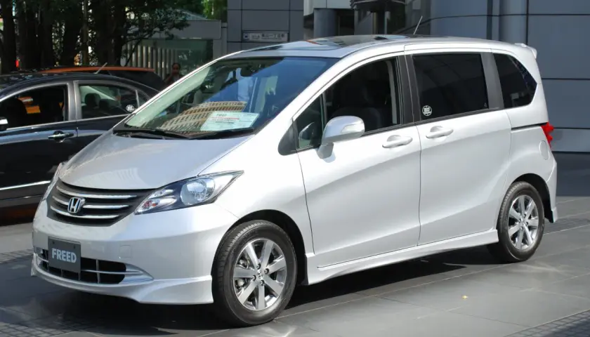 Srebrny Honda Freed stoi na tle budynku.