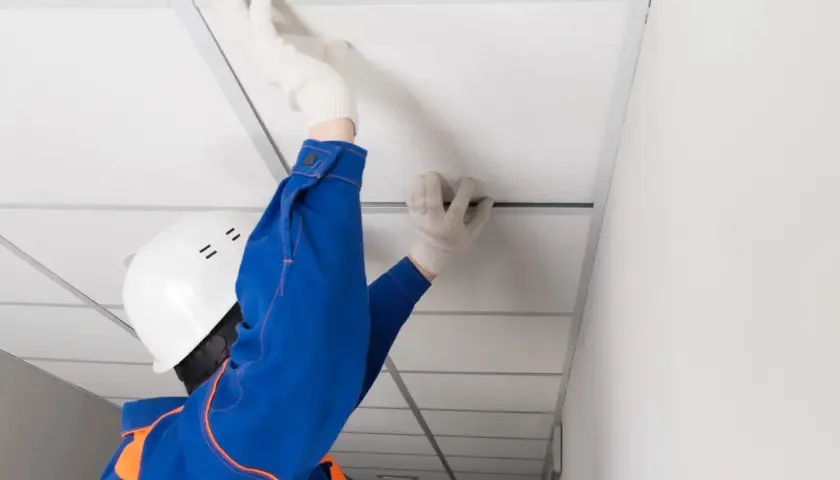 Pose d'un faux plafond dans un garage, améliorant l'isolation et l'esthétique.