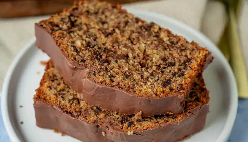 Zwei Scheiben schoko nuss kuchen mit Schokoladenglasur auf einem Teller.