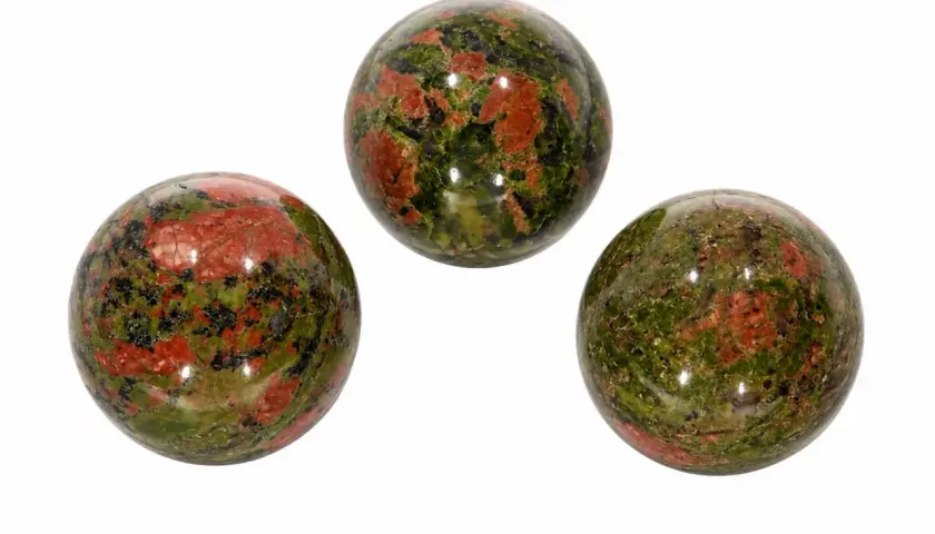 Drei polierte Kugeln aus Unakit, einem Stein mit Epidot-Einschlüssen, zeigen ein faszinierendes Muster aus Grün und Rot.