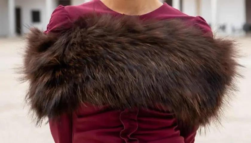 Elegante estola de pelo marrón sobre vestido burdeos, ideal para saber como llevar una estola en una boda y lucir sofisticada.