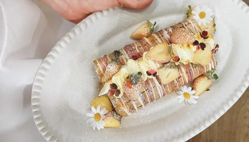 En vacker Budapestrulle med jordgubbar och blommor. Ett perfekt recept för en festlig fika!
