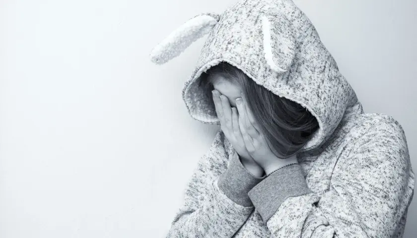 Smutna dziewczynka w bluzie z uszami, zakrywająca twarz dłońmi. Czyżby przeżywała trudne chwile, jak w opowieści o elicea?