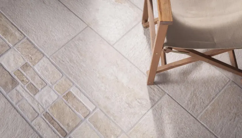 Schemi di posa piastrelle 30x60 con inserti decorativi e una sedia in legno.