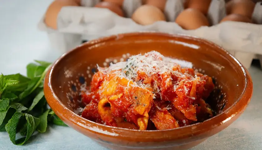 Frittata in trippa, un piatto saporito con uova e trippa in salsa di pomodoro, guarnito con parmigiano.