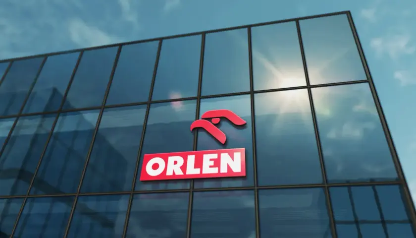 Logo ORLEN na szklanym budynku, symbolizujące najlepsze inwestycje.