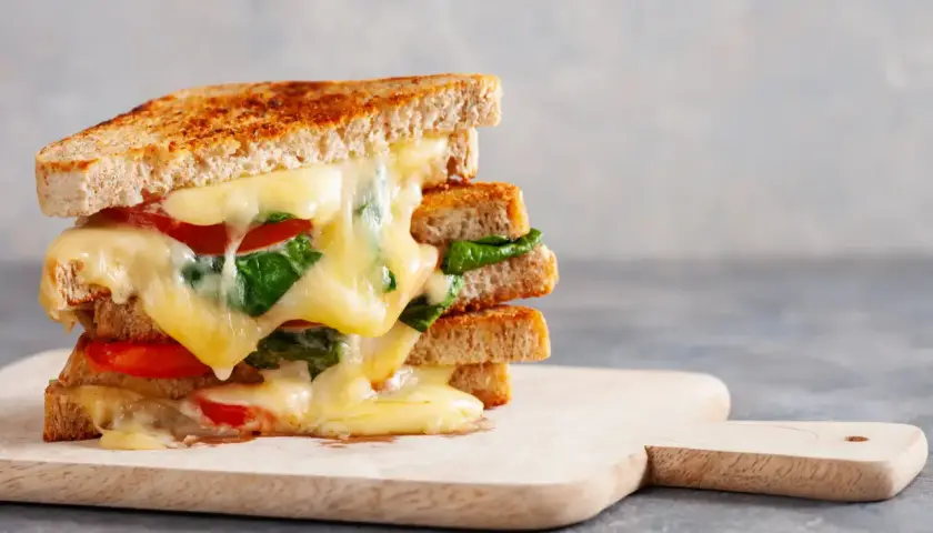 Un délicieux sandwich grillé aux tomates et épinards, une idée sandwich froid simple et gourmande. Le fromage fondant coule sur les tranches de pain.