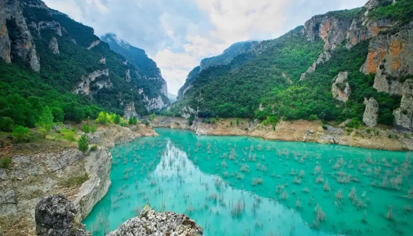 Espectacular cañón con agua turquesa y vegetación exuberante en las montañas de Cataluña.