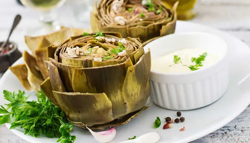 Artichauts entiers, tendres et savoureux, prêts pour la cuisson vapeur. Servis avec une sauce crémeuse et des herbes fraîches.