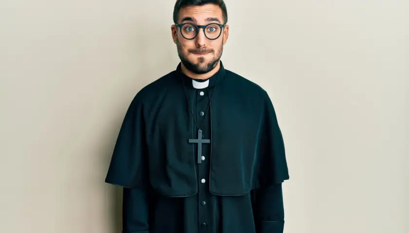 Młody ksiądz w okularach z zaciekawieniem patrzy w obiektyw. Czyżby to był sen o księdzu?