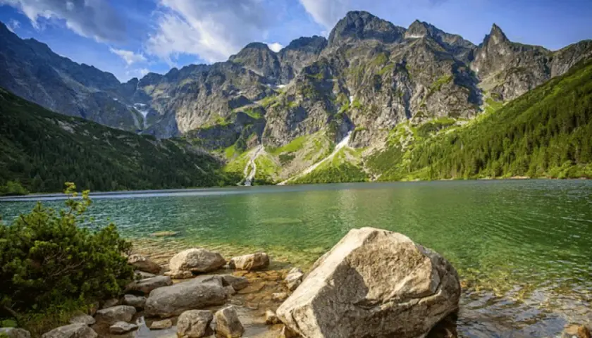 Malownicza droga nad Morskie Oko prowadzi przez skaliste wybrzeże do krystalicznie czystej wody, otoczonej majestatycznymi szczytami Tatr.