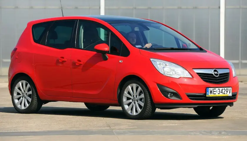 Czerwony Opel Meriva B z czarnym dachem, widziany z przodu z boku.
