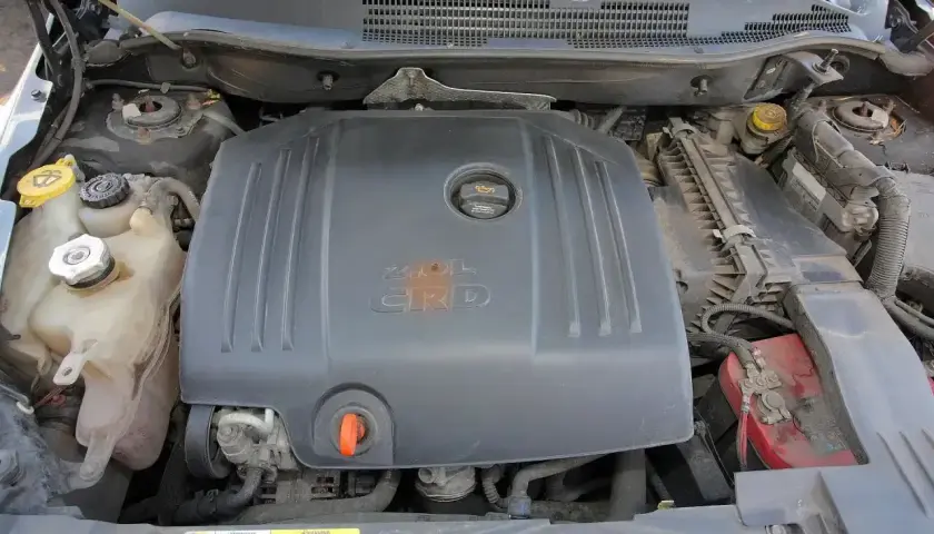Silnik 2.0L CRD w Dodge Caliber. Widoczne zbiorniczki płynów i akumulator.