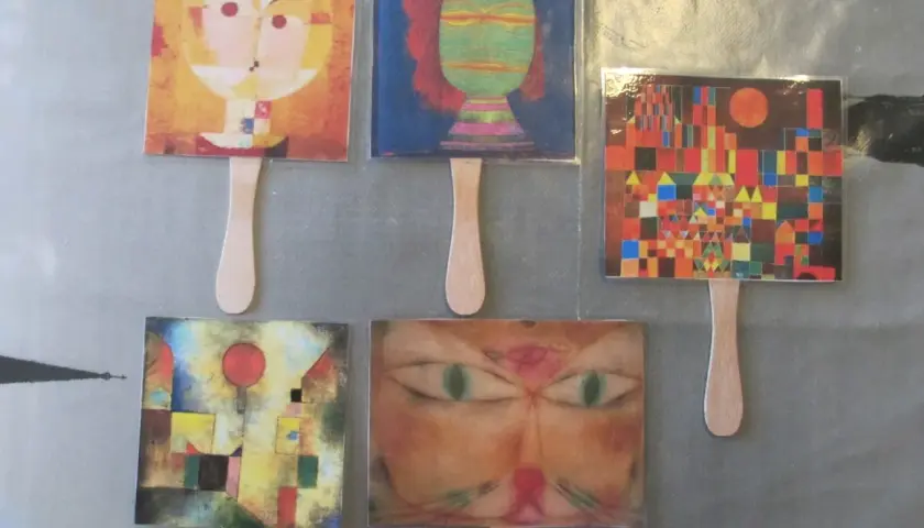 Marionetas con obras de Paul Klee para niños: rostros abstractos, un gato y un paisaje urbano colorido.