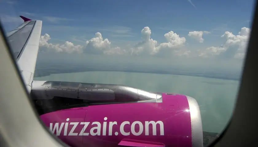 Widok z okna samolotu Wizzair na jezioro i chmury. Zastanawiasz się, ile kosztuje wybór miejsca w Wizzair?