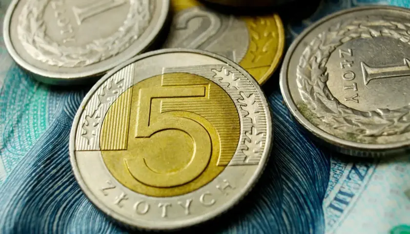 Monety 5 zł, 2 zł i 1 zł na tle banknotu. Czy to zapowiedź średniej krajowej 2026?