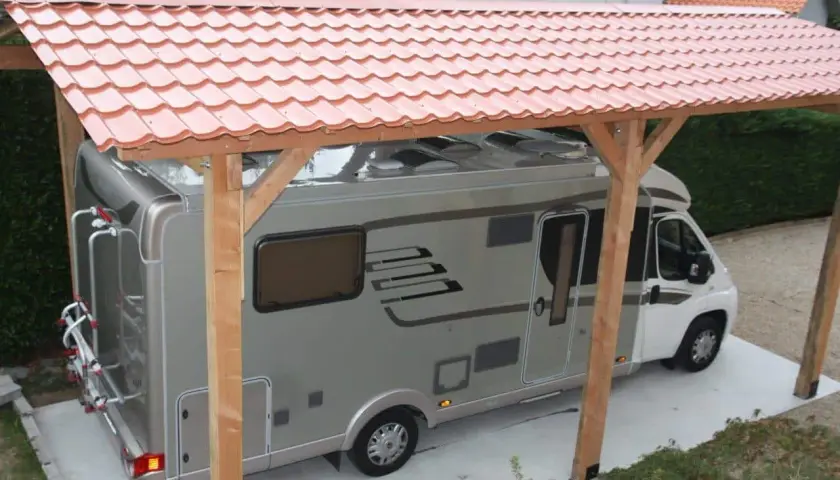 Un camping-car sous un abri simple et économique, parfait pour fabriquer un abris camping-car pas cher.