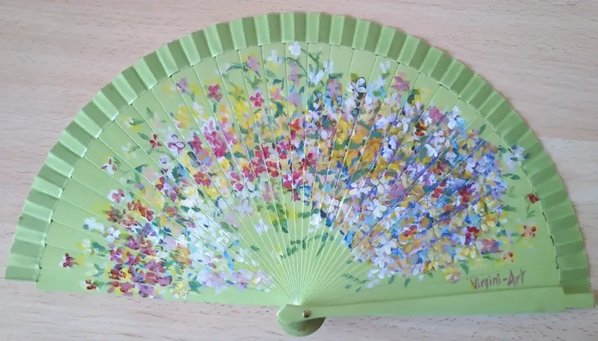 Abanico verde claro pintado con flores de muchos colores. ¡Perfecto para inspirar dibujos fáciles para pintar abanicos!