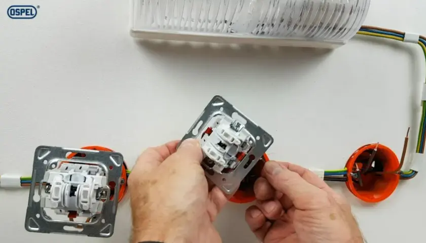 Montaż łącznika krzyżowego. Schemat instalacji elektrycznej z widocznymi przewodami i puszkami instalacyjnymi.