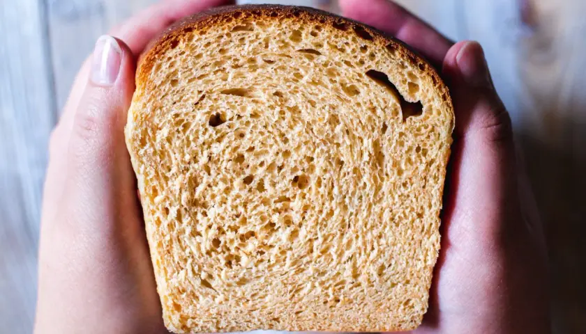 En skiva gyllene bröd, perfekt för en frukost istället för sirap. Hålls varsamt i två händer.