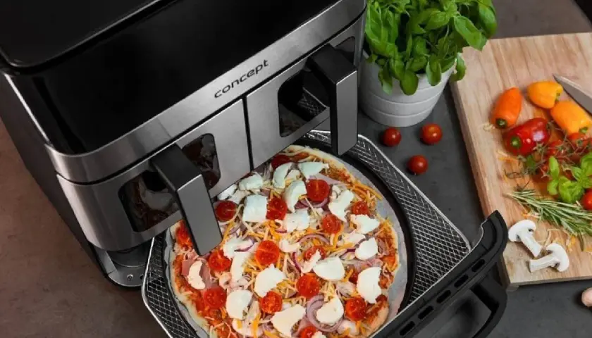 Gotowa do pieczenia pizza w air fryerze. Pyszna, domowa pizza z pomidorami i mozzarellą w zasięgu ręki dzięki nowoczesnemu urządzeniu.