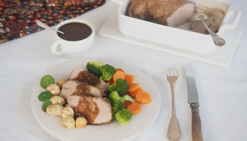 Tranches de filet mignon, accompagnées de légumes verts et de carottes, nappées d'une sauce savoureuse. La cuisson parfaite du filet mignon est mise en valeur.