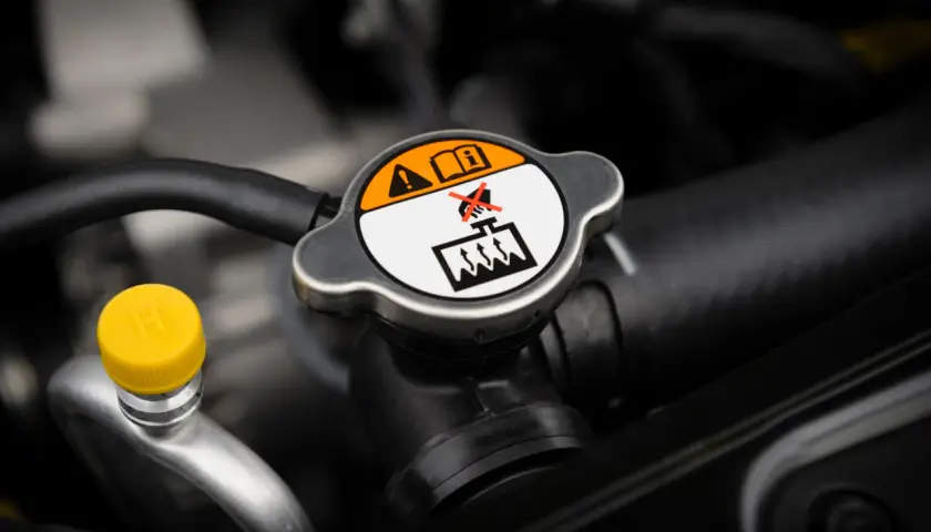 Tapa del radiador con advertencias. Es normal que un coche consuma anticongelante, pero revisa el nivel.