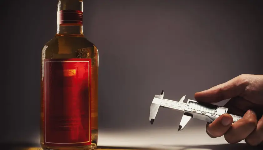 Caliper mierzy zawartość alkoholu w butelce wódki.