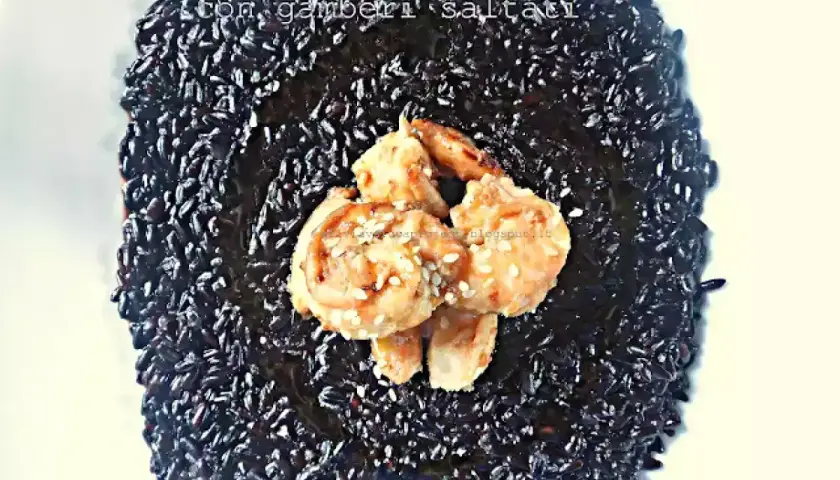 Riso Venere profumato al limone con gamberi saltati, un piatto elegante e saporito.
