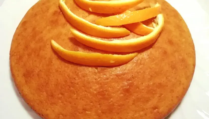 Torta all'arancia morbidissima, decorata con scorzette fresche. Un dolce profumato e invitante.
