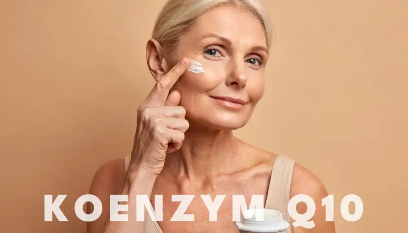Kobieta aplikuje krem pod oczy. Czy wiesz, co to jest koenzym Q10? To składnik, który może pomóc w pielęgnacji skóry.