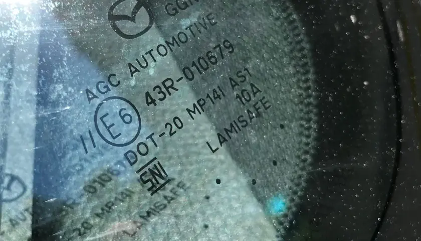 Widoczne oznaczenia na szybach samochodowych: AGC AUTOMOTIVE, E6, 43R-010679, DOT-20, LAMISAFE.