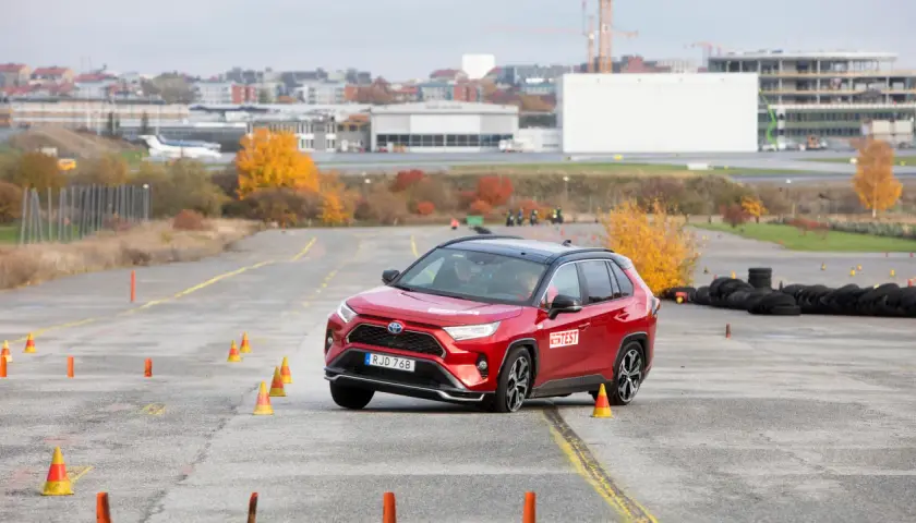 Röd Toyota RAV4 Hybrid genomför ett test på en bana med koner. En bil som testas för att se om det finns något toyota rav4 hybrid problem.