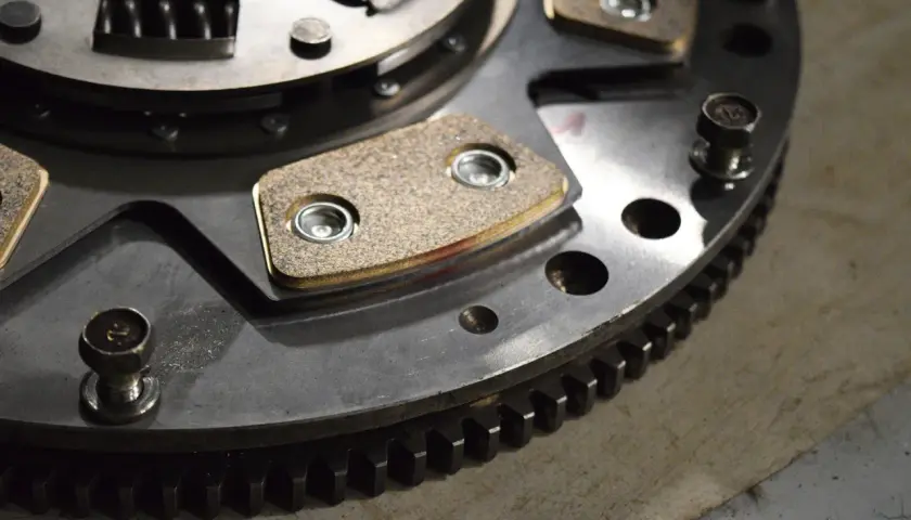 Metalowe elementy sprzęgła w automacie, z widocznymi okładzinami ciernymi i zębatym wieńcem.