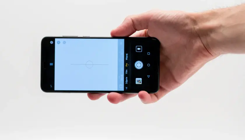 Dłoń trzyma smartfon Huawei P20 Pro z włączonym aparatem w trybie Pro, gotowy do zrobienia idealnego ujęcia.