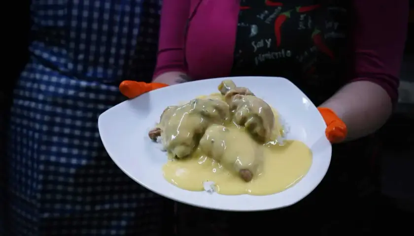 Porcja ryżu z kurczakiem w kremowym sosie potrawkowym, podana na białym talerzu.