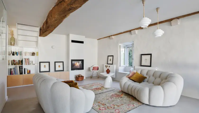 Salon cosy avec cheminée et canapés arrondis. La ventilation appartement est discrète, intégrée au design moderne.