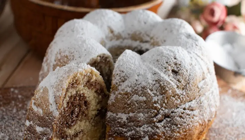 Puszysta babka włoska z marmurkowym wnętrzem, obficie posypana cukrem pudrem. Idealna na deser.