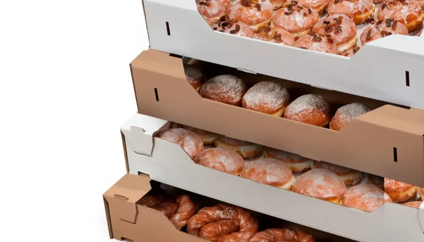 Pączki w pudełkach, gotowe na Tłusty Czwartek. Różne rodzaje słodkości czekają na świętowanie.