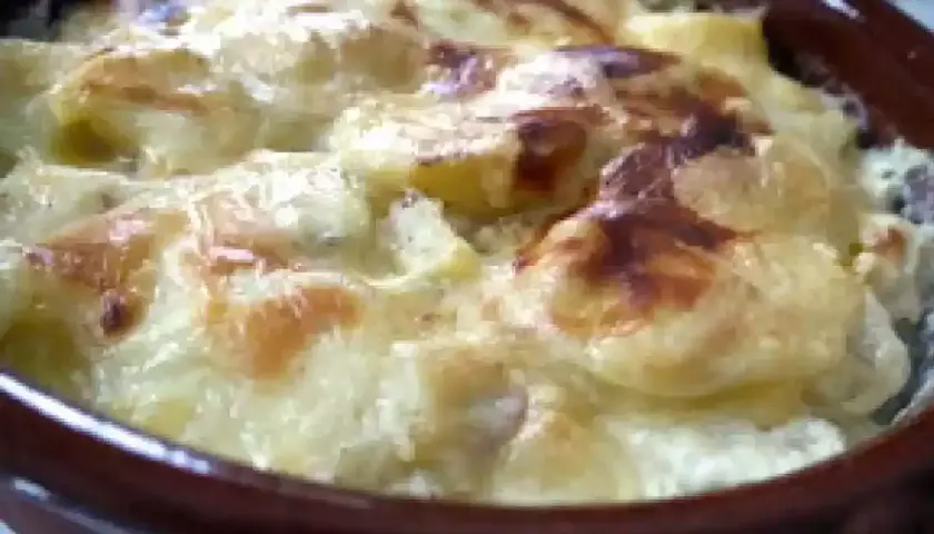 Pommes de terre, lardons et fromage raclette gratinés au four, un plat réconfortant et savoureux.