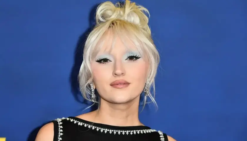 Młoda kobieta z blond włosami upiętymi w kok, z błękitnym makijażem oczu i błyszczącymi kolczykami. Ciekawe, ile lat ma Hania?