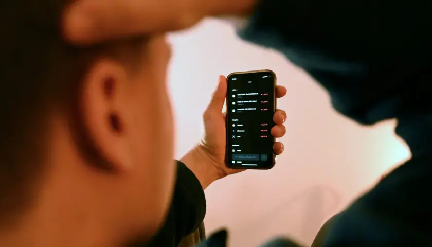 Person prüft mit **scalable capital vollmacht** auf dem Smartphone Aktienkurse und Kryptowährungen.