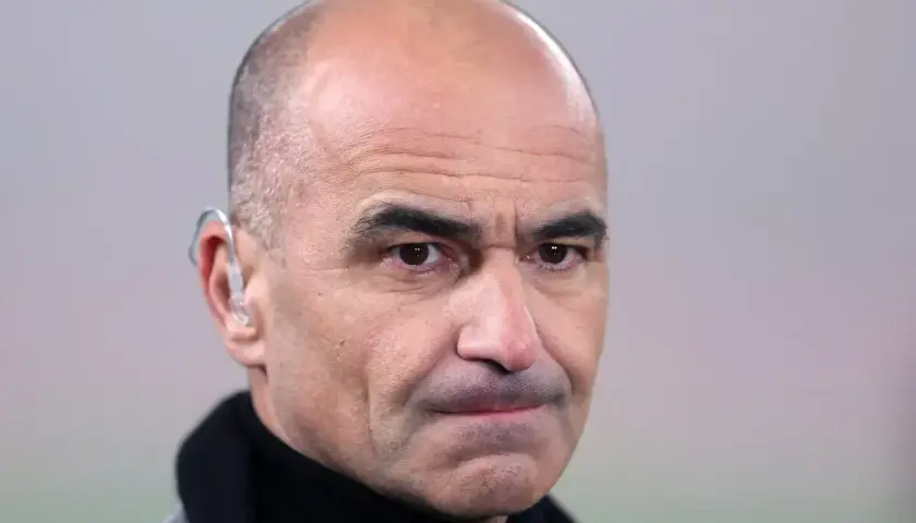 Martinez, trener z charakterystycznym aparatem słuchowym, patrzy wprost.