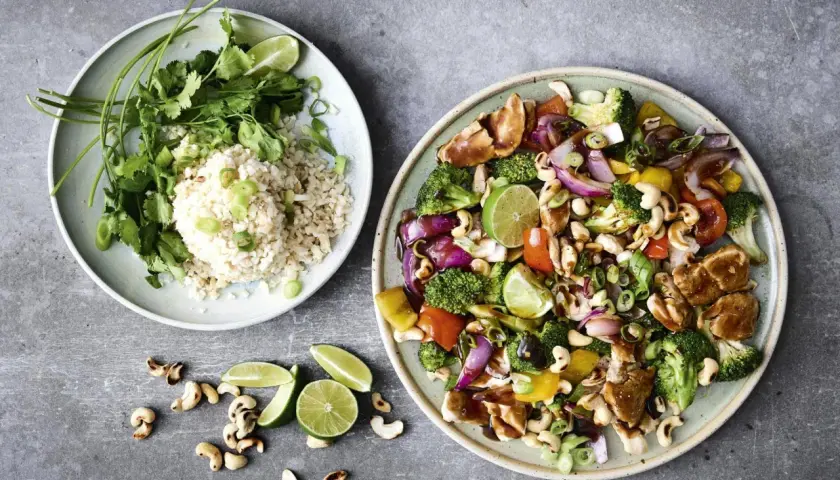 En färgstark wok med kyckling, grönsaker och cashewnötter, serverad med ris. Ett perfekt recept med ingredienser man har hemma.