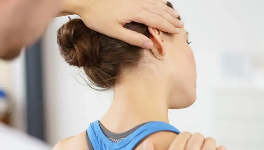 Physiotherapeut behandelt Verspannungen am Nacken. Ein sanfter Druck löst das Knacken im Nacken.
