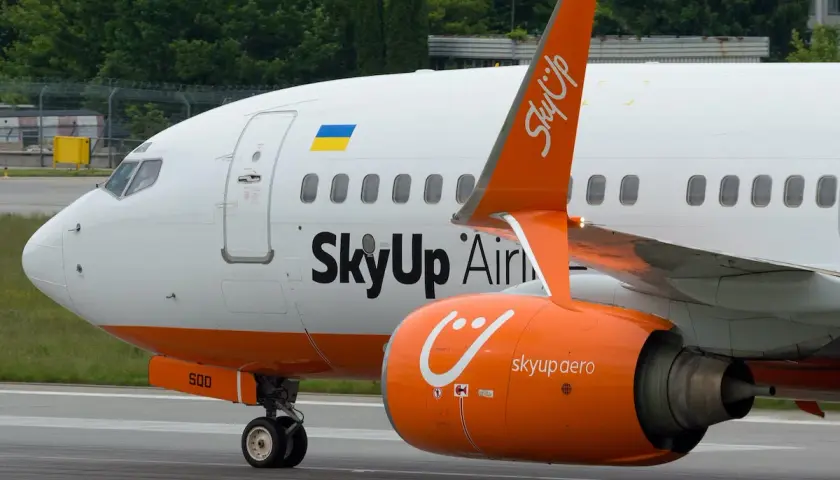 Samolot SkyUp Airlines z pomarańczowym silnikiem i charakterystycznym logo.