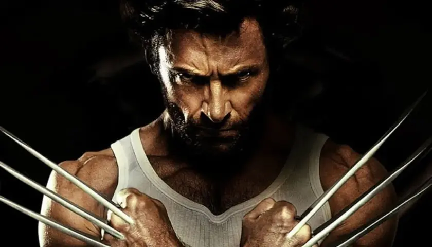 Wolverine po polsku, z pazurami wysuniętymi, w białej podkoszulce, patrzy groźnie.