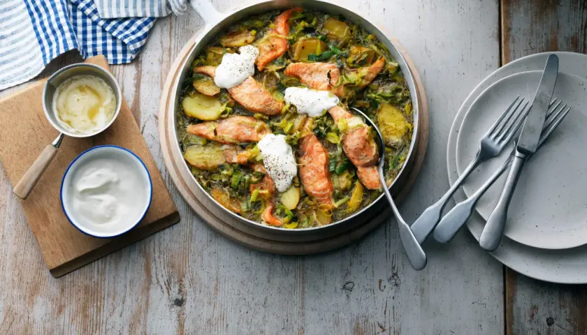 En härlig laxrätt med potatis och purjolök, toppad med en klick gräddfil. Ett perfekt lax recept för en mysig middag.