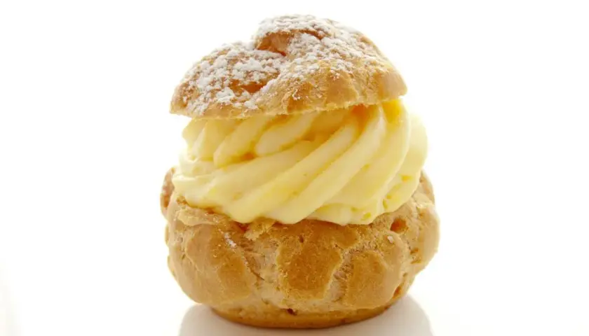 Un déliceux chou à la crème, saupoudré de sucre glace, avec une généreuse garniture de crème pâtissière onctueuse.