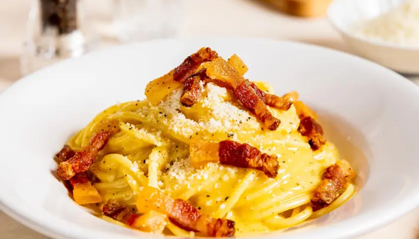 Ein Teller mit authentischer Spaghetti Carbonara, garniert mit knusprigem Guanciale und Pecorino. Ein wahrer Genuss der italienischen Küche.